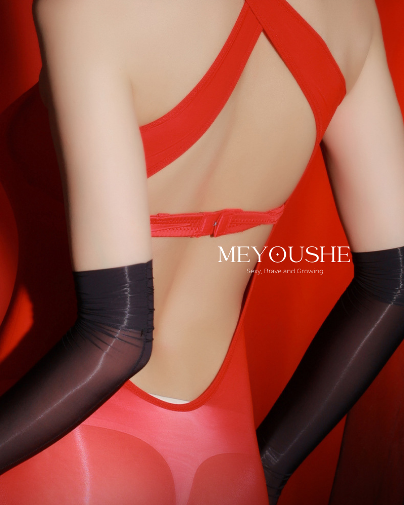 Model posing in Veyra cross halter bodysuit, highlighting stretchy fabric and elegant silhouette